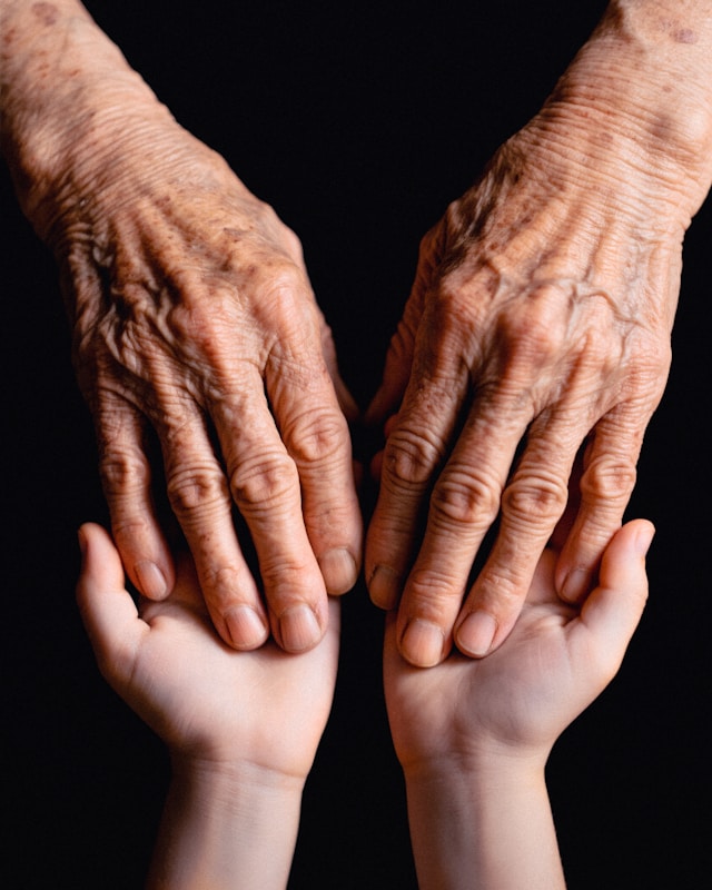 older person holding hands with younger one