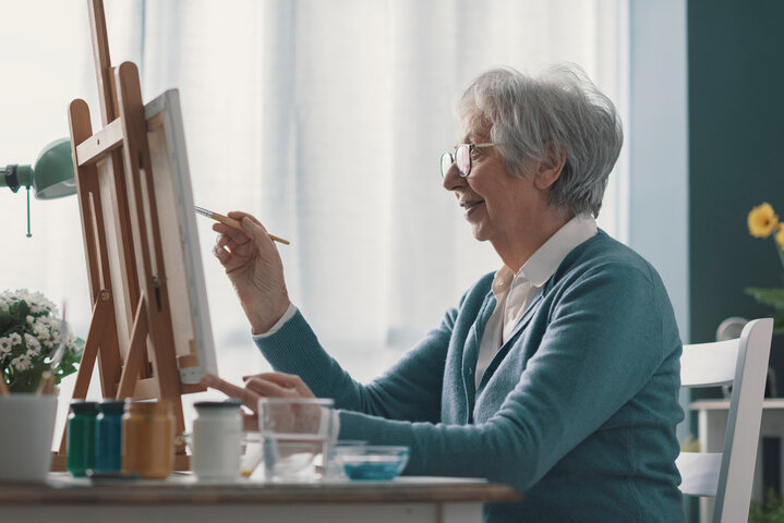 older woman painting a canvas