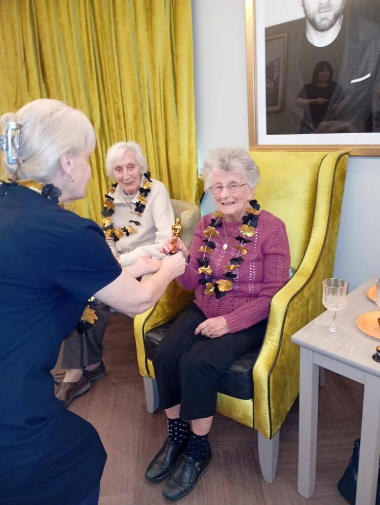 resident receiving an award frmo the home manager 