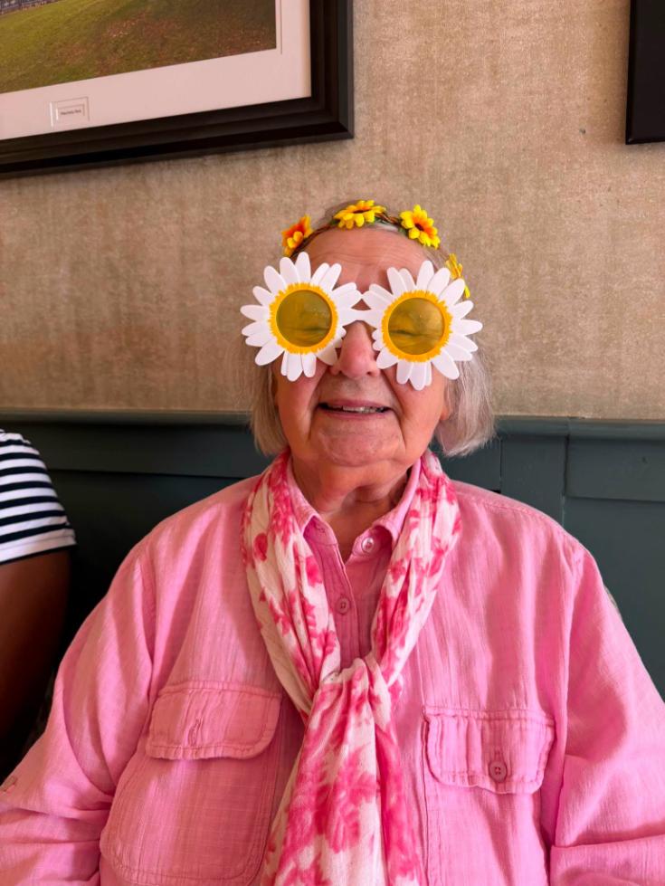 resident with costume glasses on at the summer bbq